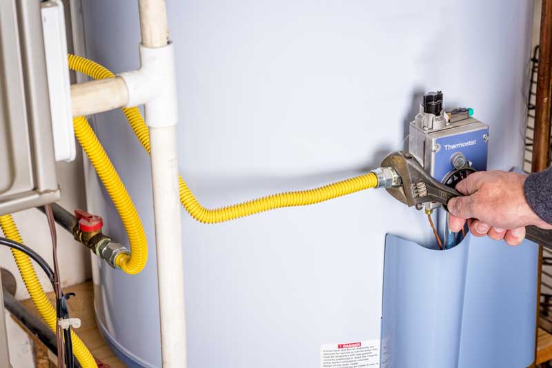 Plumber Adjusting Water Heater Thermostat with Wrench
