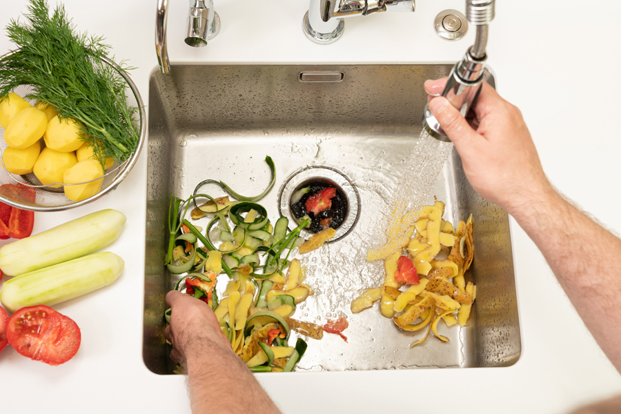 Kitchen sink with food scraps being washed down the drain